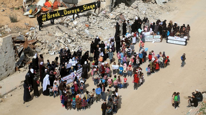 People protest in the besieged town of Daraya, Syria. More than 12 million people in the country still do not have access to clean water and nearly 9 million do not have enough to eat.