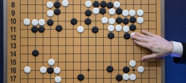 A commentator in a media room positions pieces forming a replica of a game between 'Go' player Lee Se-Dol and the Google-developed AlphaGo program, in Seoul on March 13, 2016.