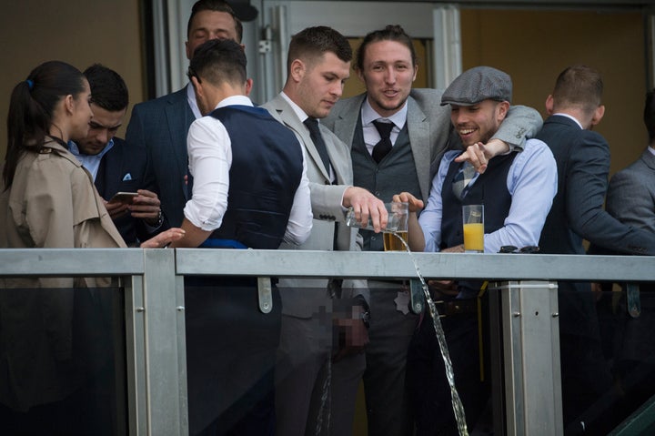 The liquid is thrown over the balcony as Carruthers looks on, smiling.