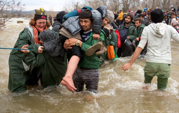 Migrants try to cross a river after leaving the Idomeni refugee camp on March 13, 2016, in Greece. One million migrants