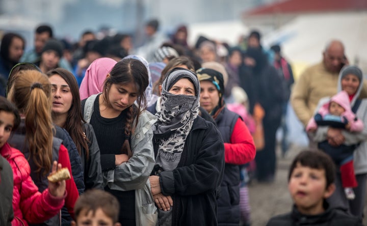 People wait for food aid at the Idomeni refugee camp on the Greek Macedonia border on March 16, 2016 in Idomeni, Greece.