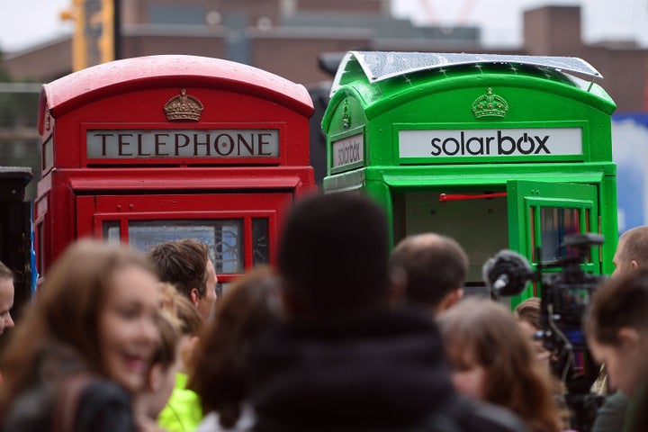 The first traditional London telephone box (R) to be transformed into a solar-powered mobile phone charger for use by the public, is pictured next to a traditional red telephone box in central London, on October 1, 2014. Use of the facility is expected to be free of charge.