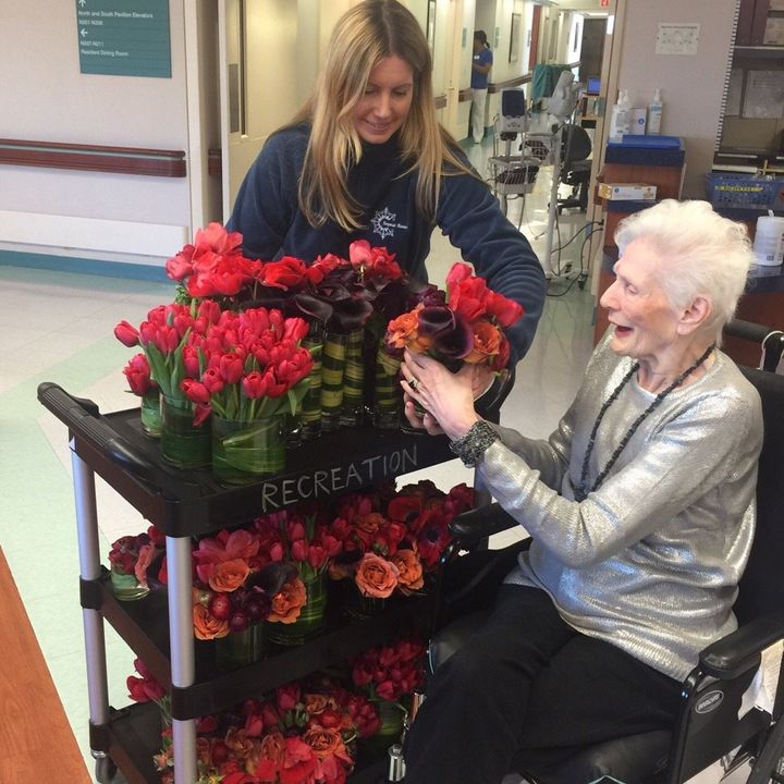 Jennifer Grove, Founder and CEO of Repeat Roses, presents flowers to Barbara, a resident of Menorah Center for Rehabilitation and Nursing Care in Brooklyn, NY.