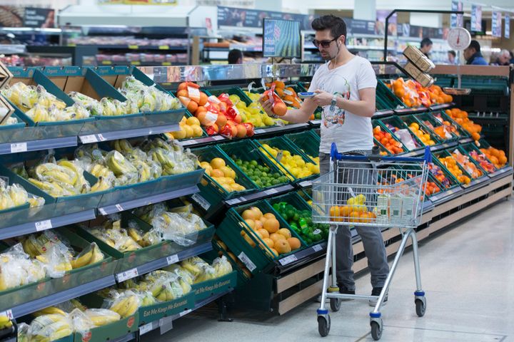 A customer shops at a Tesco supermarket in London. Tesco, one of the world's largest grocery chains, finalized a plan to cut food waste in its stores this week.