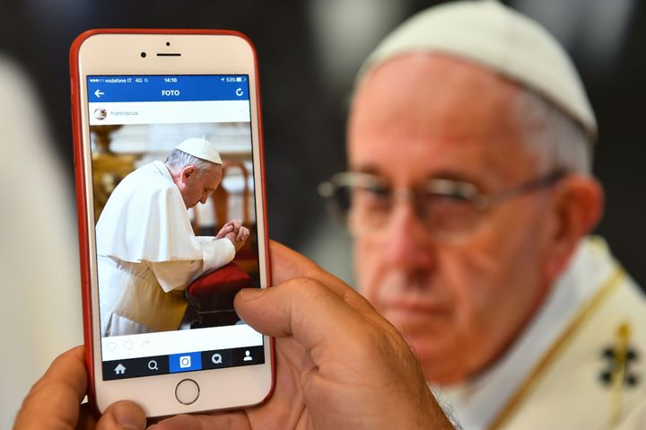 A man looks at the Instagram account of Pope Francis on March 19, 2016 in Rome