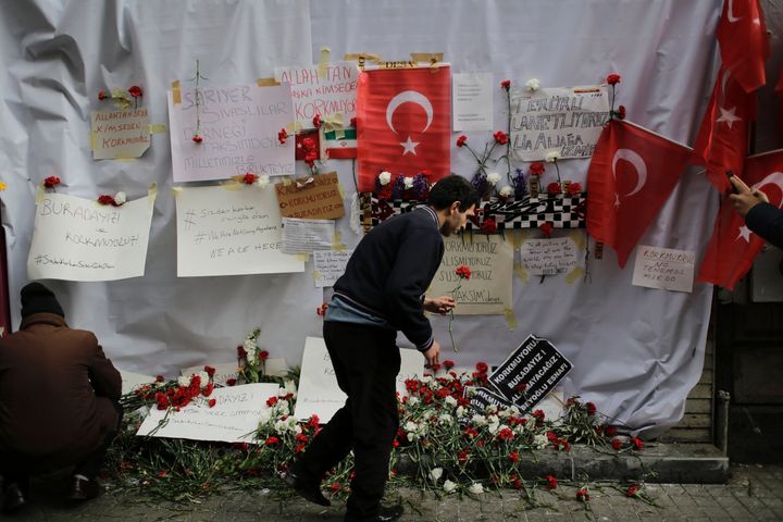 A mourner places a flower at the scene of the terror attack in Istanbul that killed four people and injured 39