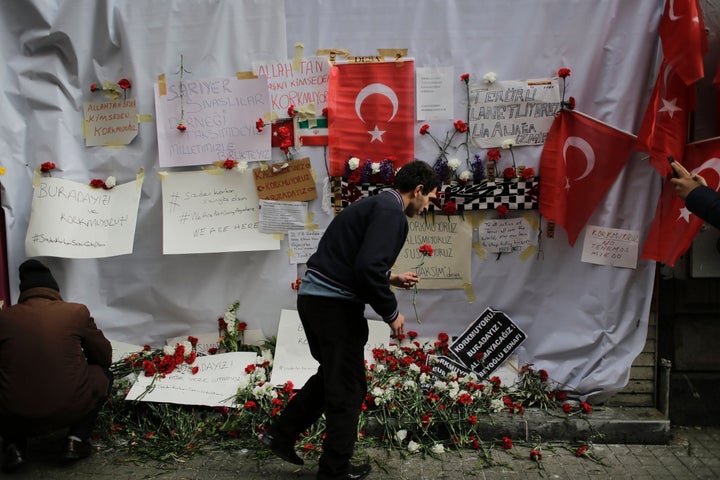 A mourner places a flower at the scene of the terror attack in Istanbul that killed four people and injured 39