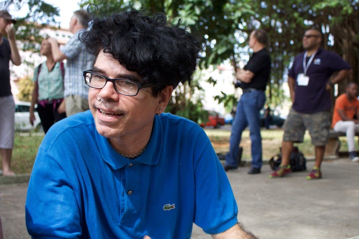 Gorki Aguilar, the frontman for punk band Porno Para Ricardo, sits on a curb in a park next to the Santa Rita church, where the Ladies in White group holds weekly protests.