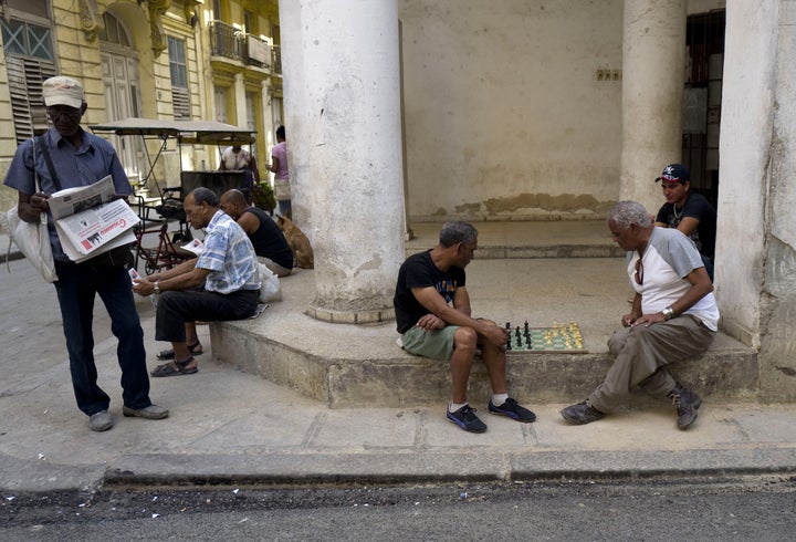 Men read the state newspaper Granma while others play chess in Old Havana on March 17, 2016. Obama arrived in Havana on Sunday.