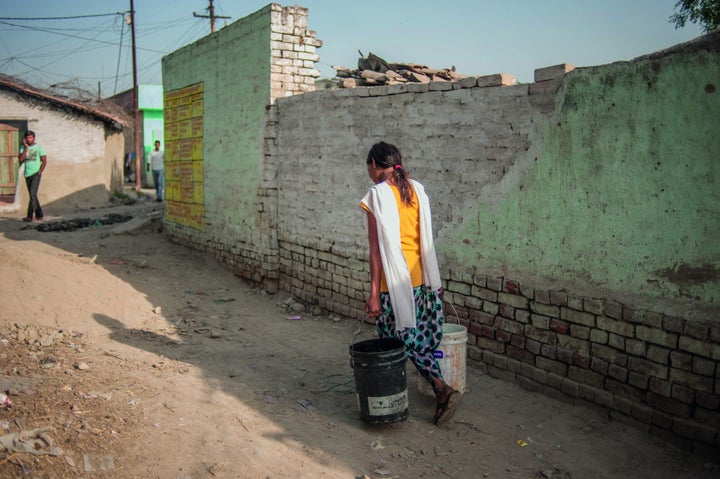 A teen on her way to collect water in Kanpur, India.