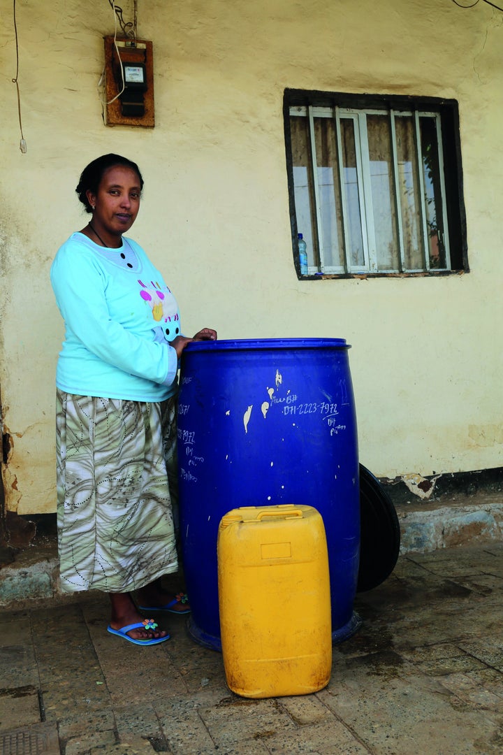 Biruktawit stands near a water container in Leku Keta, in Oromia, Ethiopia.