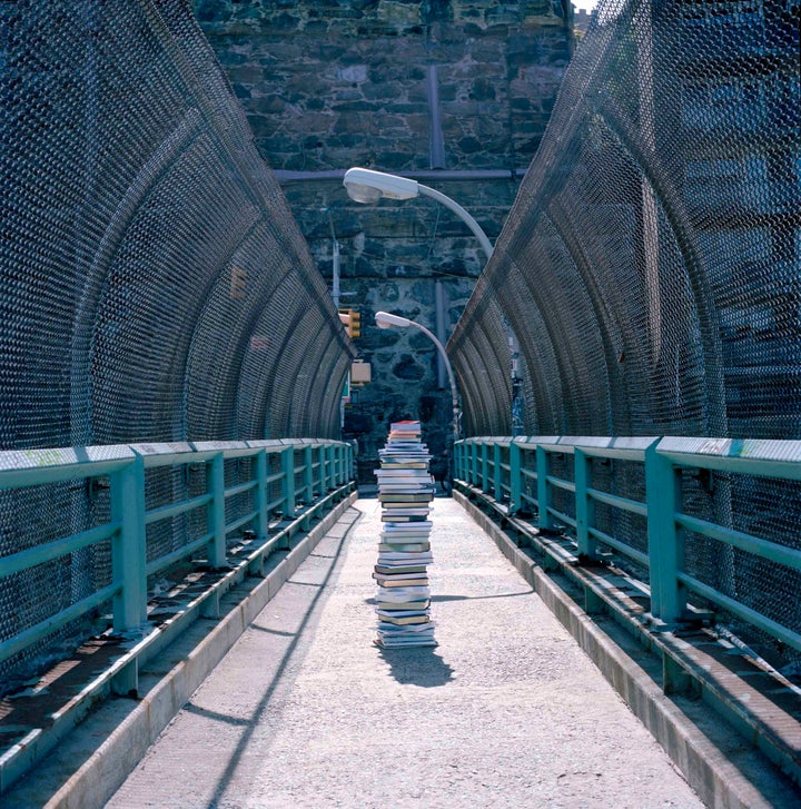 Stack of books left on a footbridge above a highway near the Washington Bridge.