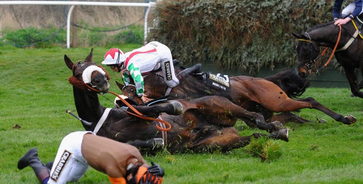 Sam Waley-Cohen (foreground) falls from on Long Run with another jockey at Valentine's during the Crabbie's Grand National Steeple Chase at Aintree Racecourse on April 5, 2014 in Liverpool