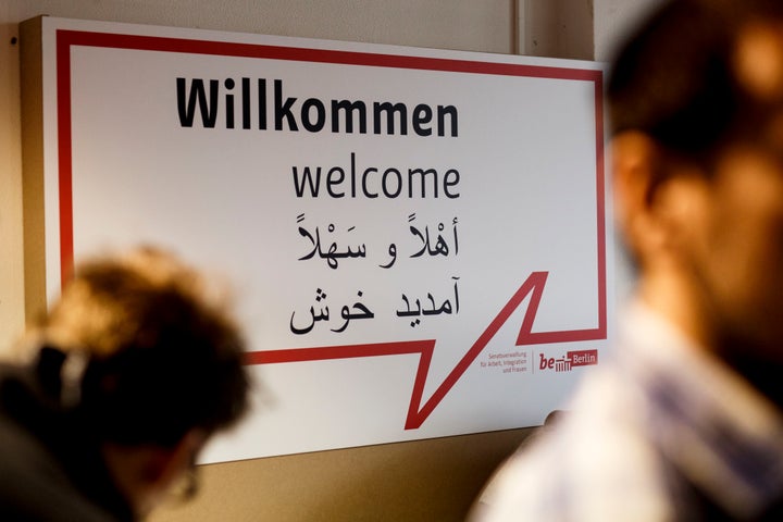 Volunteers in front of a welcome sign at a new jobs counseling center for migrants and refugees at former Tempelhof Airport on Feb. 25, 2016, in Berlin, Germany.