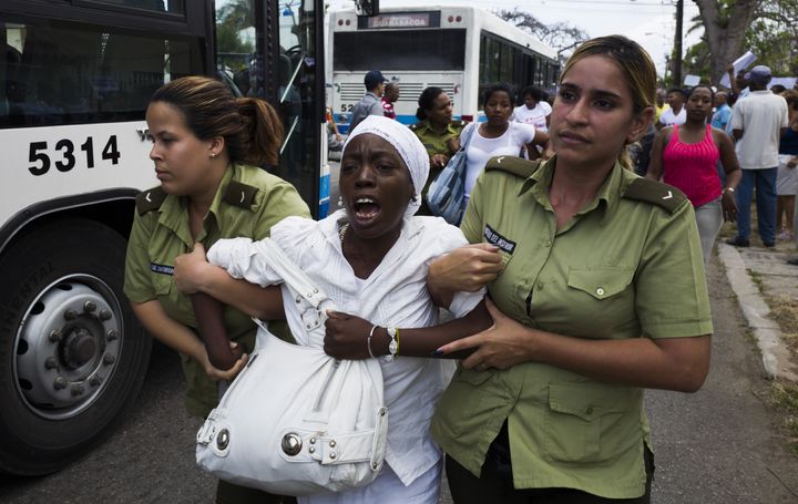 A member of the Ladies in White, a group founded by partners and relatives of jailed dissidents, is led away by police officers hours before U.S. President Barack Obama began his visit to Havana on Sunday.