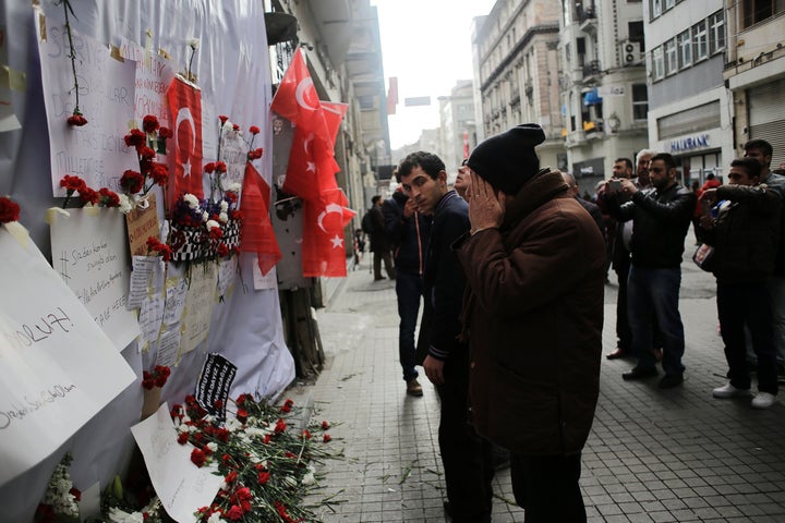 A man reacts in front of a makeshift memorial at the location of the blast of a suicide attack on Istiklal Street, a major sh