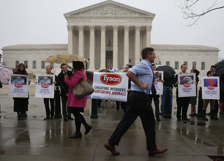 Activists protest against Tyson Foods in front of the Supreme Court on Nov. 10, 2015. Meatpacking workers at a Tyson Foods plant scored a big win at the high court on Monday.