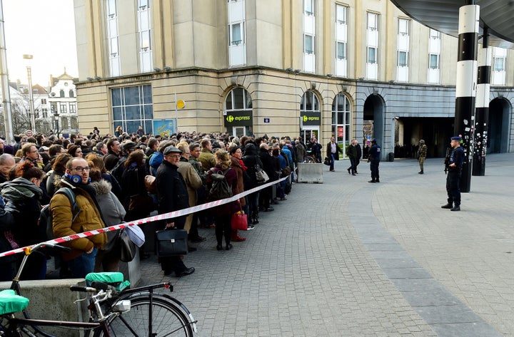 Belgian soldiers and police stand at a cordon set to limit the number of people allowed into the central station in Brussels