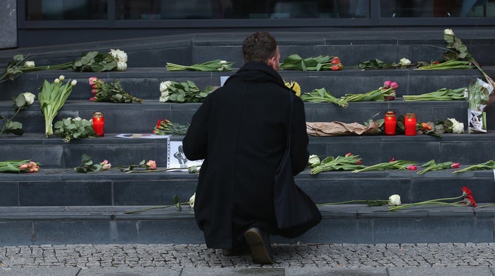 A man lays flowers at the steps of the Belgian Embassy in Berlin. World leaders reacted with shock and solidarity after the attacks.