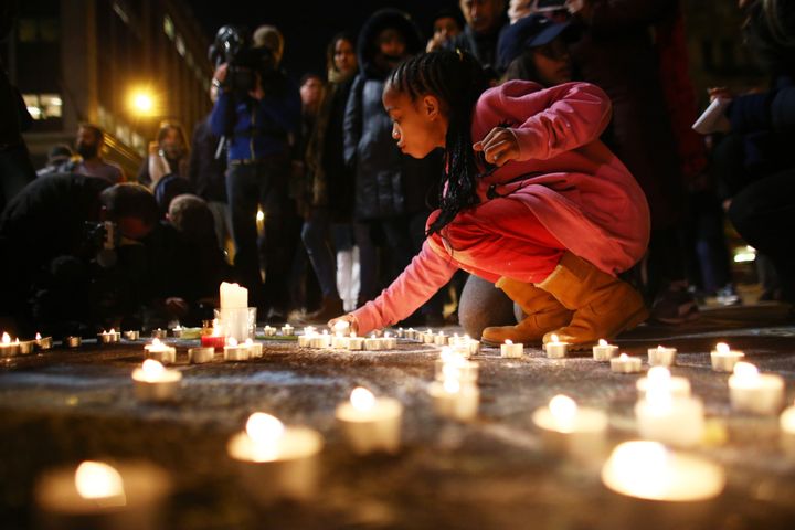 A young girl lights a candle at the Place de la Bourse following today's attacks on March 22, 2016 in Brussels, Belgium