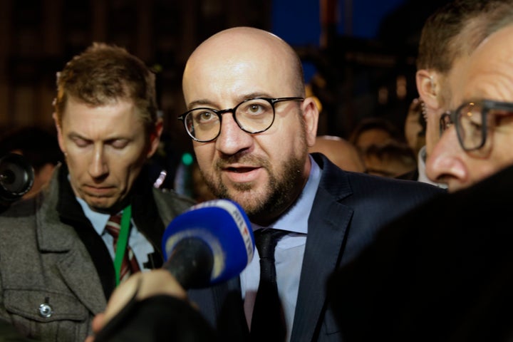 Belgian Prime Minister Charles Michel speaks to the press at a makeshift memorial in front of the stock exchange at the Place de la Bourse in Brussels on March 22, 2016