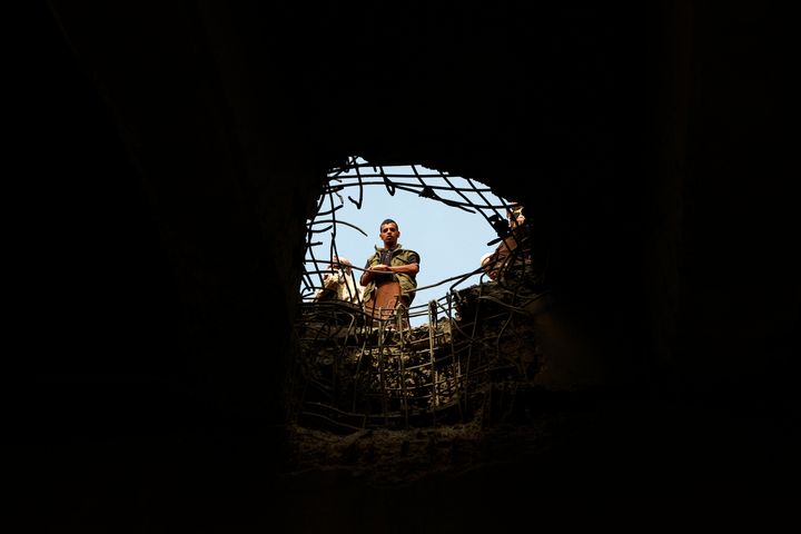 At least 50 militants were killed in a U.S. air strike on an al Qaeda training camp in southern Yemen that struck as recruits lined up for dinner at the camp. Above, a man checks the damage following reported air strikes in Sanaa.