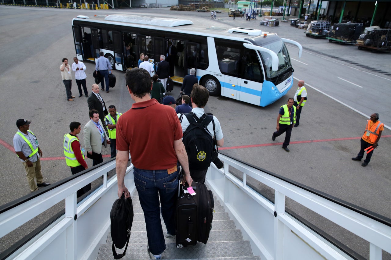 Passengers walk off the White House charter plane after landing at José Martí International Airport in Havana a day before Obama's arrival.