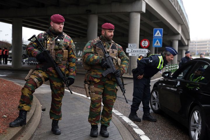 Belgian soldiers stand guard as police check vehicles outside of the closed Brussels Zaventem airport on March 23, 2016 in Brussels, Belgium