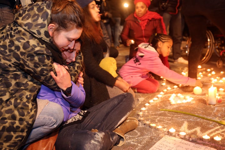 Two young girls cry as people gather to leave tributes at the Place de la Bourse in Brussels, Belgium, following Tuesday's terrorist attacks.