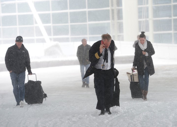 DENVER, CO - March 23: Airline passengers and a pilot make their way to the Westin Hotel at the Denver International Airport in bitter winds and heavy snow March 23, 2016. (Photo by Andy Cross/The Denver Post via Getty Images)