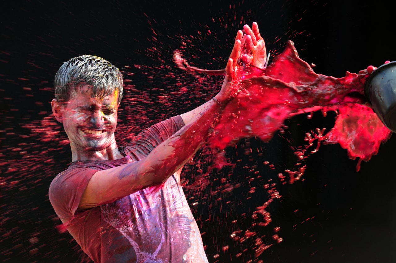 An Indian man get his face smeared with colors as he takes part in Holi celebrations in Chennai