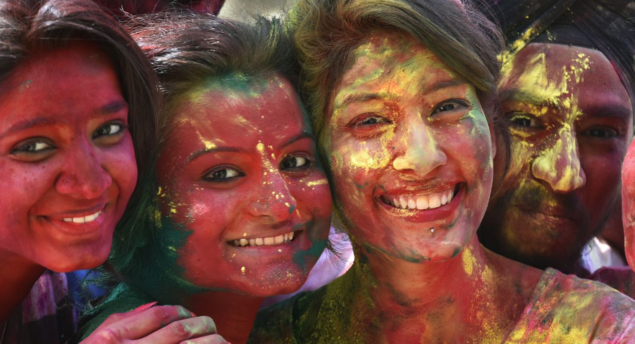 Students apply Gulal (dry colored powder) on each other before the Holi festival outside YMCA in New Delhi.