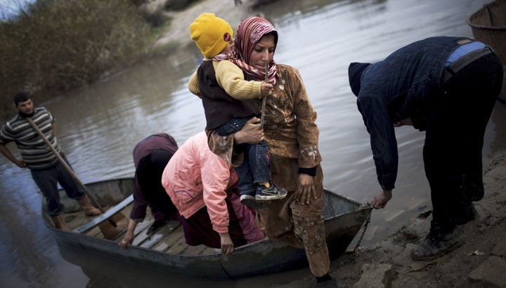 Syrian refugees cross from Syria to Turkey by the Orontes river, near the village of Hacipasa, Turkey on Dec. 8, 2012.