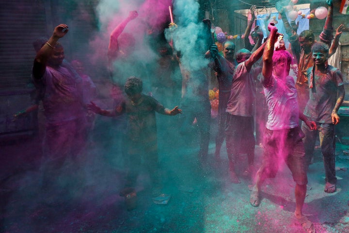 Men dance as others throw colored powder on them during Holi celebrations in Kolkata, India, March 24, 2016.