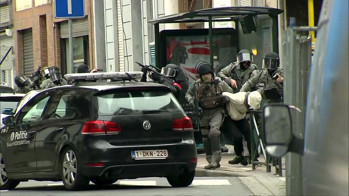 This still image taken from a video shows armed Belgian police apprehending a suspect in Molenbeek, Belgium, on March 18.