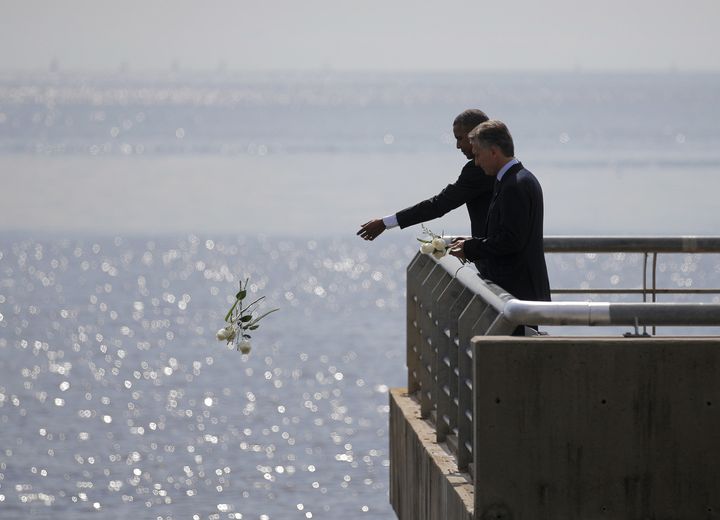 President Barack Obama and Argentina's President Mauricio Marci throw flowers into the River Plate to honor victims of the Dirty War. 