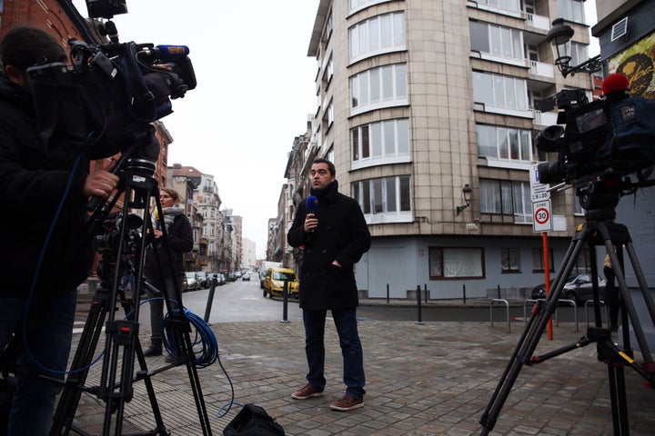 A broadcast journalist works outside the apartment block believed to be used by brothers Khalid and Brahim el-Bakraoui before their suicide attack at the airport