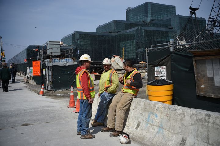 Construction workers chat during their break at a building site in New York on March 24, 2016. Latinos are over-represented in physically demanding fields like construction.