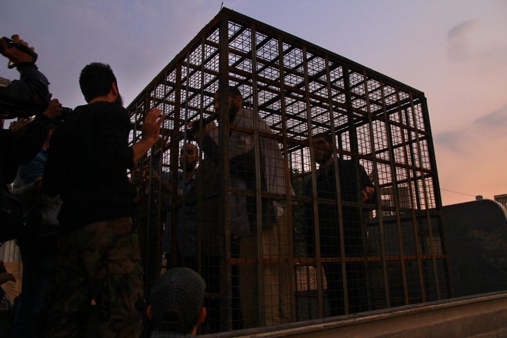 Syrians are seen inside imprisoned in a cage in Douma last August, an area held by Jaish al-Islam. Syrians say torture and imprisonment are routine in the Syrian areas the group control.