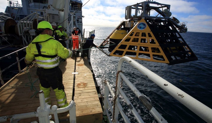 Marine biologist Peter Linke, GEOMAR engineers and deckhands guide a specially-designed lander (commissioned by Norway's Centre for Arctic Gas Hydrate, Environment and Climate (CAGE)) over the edge of RV Helmer Hanssen to begin a one-year seafloor mission monitoring marine methane off west coast of Spitsbergen, Svalbard archipelago, Norway.