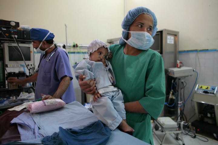 KABUL, AFGHANISTAN - NOVEMBER 9: Subada, 18 months, is held by a nurse before her cleft lip and palate operation at a special clinic to help cleft lip and palate patients at the CURE International hospital in Kabul, Afghanistan November 9, 2006. In order to address cleft lip/palate disabilities, CURE International has launched CURE Smiles, in partnership with Smile Train, a non-profit organization that raises money primarily in the U.S. to fund the specialized surgeries in many third world countries. Nine hundred cleft lip and palate surgeries over the next year will be performed by CURE Smiles in Afghanistan while training local surgeons in conjunction. The treatment is free while Afghans are only charged a small registration fee. (Photo by Paula Bronstein/Getty Images)