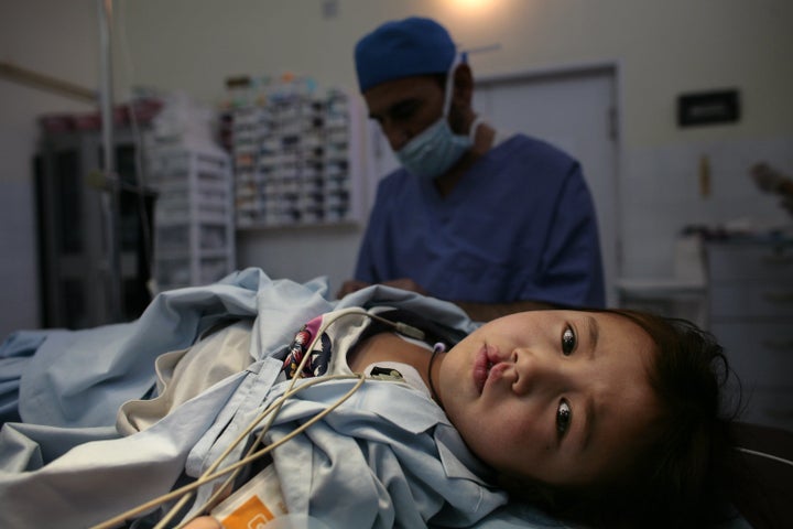 KABUL, AFGHANISTAN - NOVEMBER 9: Sakima, 7, lays on the operation table before surgery starts to fix her right cleft lip at a special clinic to help cleft lip and palate patients at the CURE International hospital in Kabul, Afghanistan November 9, 2006. In order to address cleft lip/palate disabilities, CURE International has launched CURE Smiles, in partnership with Smile Train, a non-profit organization that raises money primarily in the U.S. to fund the specialized surgeries in many third world countries. Nine hundred cleft lip and palate surgeries over the next year will be performed by CURE Smiles in Afghanistan while training local surgeons in conjunction. The treatment is free while Afghans are only charged a small registration fee. (Photo by Paula Bronstein/Getty Images)