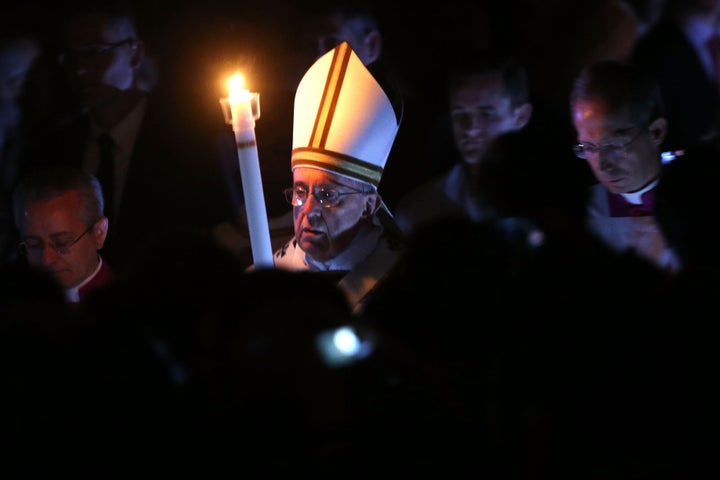 Pope Francis holds the Paschal candle as he arrives at St. Peter's Basilica for the Easter vigil mass on April 4, 2015 in Vat