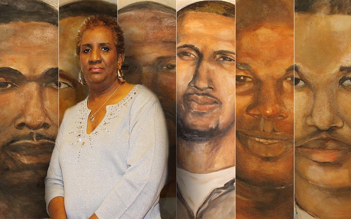 Sheila Phipps stands next to a portrait she painted of her son, McKinley "Mac" Phipps Jr., and other men incarcerated in Louisiana.