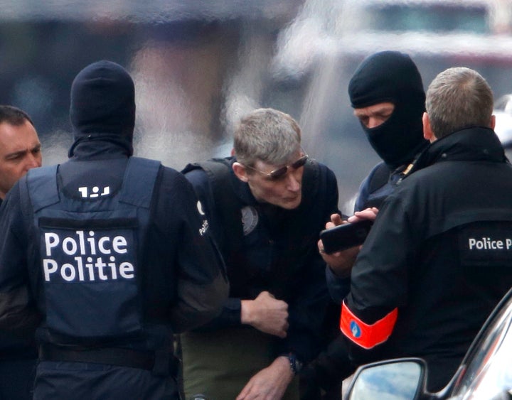 Belgian prosecutors charged three men with terrorism on Saturday. Above, police search people in Brussels after the attacks.