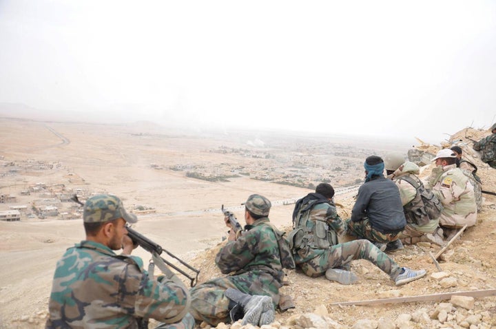 Forces loyal to Syria's President Bashar al-Assad take positions on a look-out point overlooking the historic city of Palmyra in Homs Governorate in this handout picture provided by SANA on March 27, 2016.