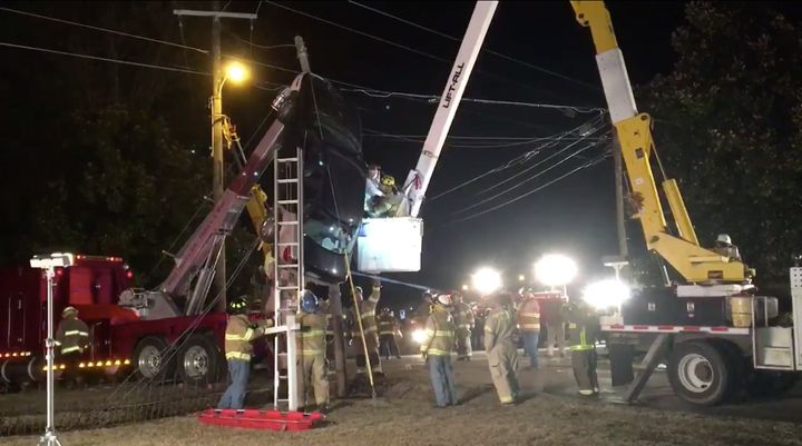 A woman is rescued from her car after it somehow became trapped in power lines.