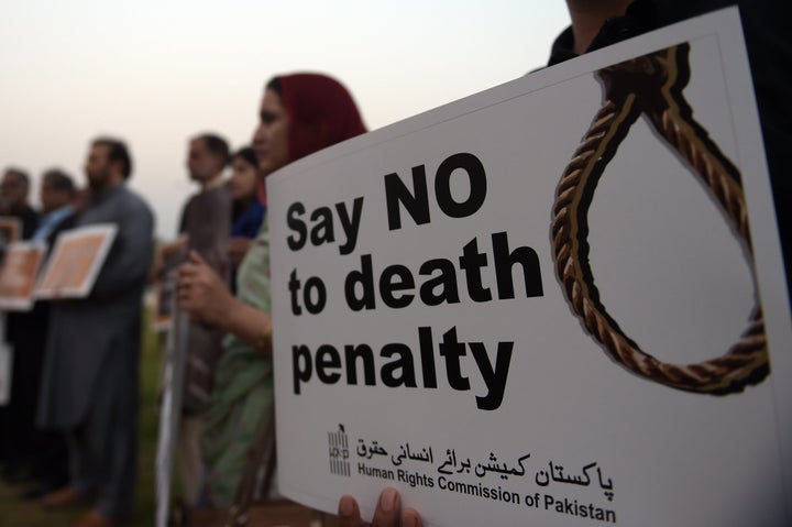 Activists from the Human Rights Commission of Pakistan carry placards during a demonstration to mark International Day Agains