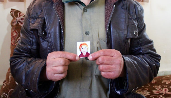 Abdel Qadir, a father of eight who survived the U.S. attack on the&nbsp;Kunduz hospital, holds up an undated picture of his d