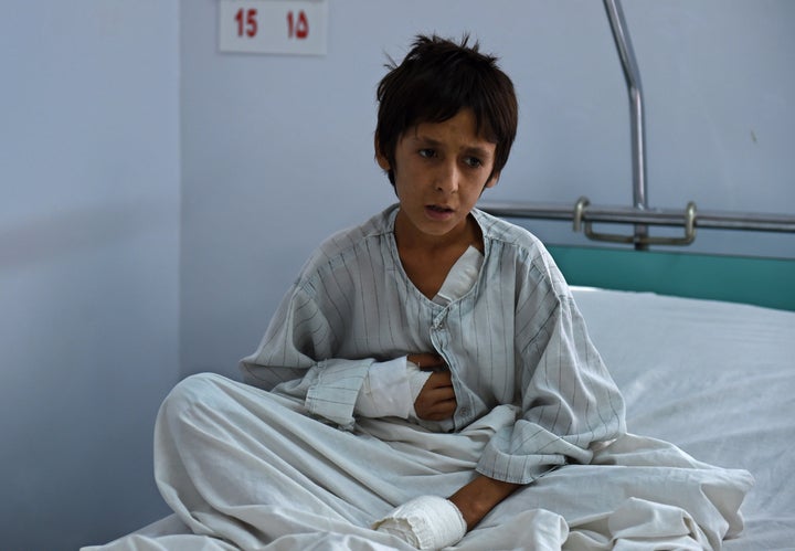 A wounded Afghan boy who survived U.S. airstrikes on the MSF Hospital in Kunduz sits on his bed at the Italian-run